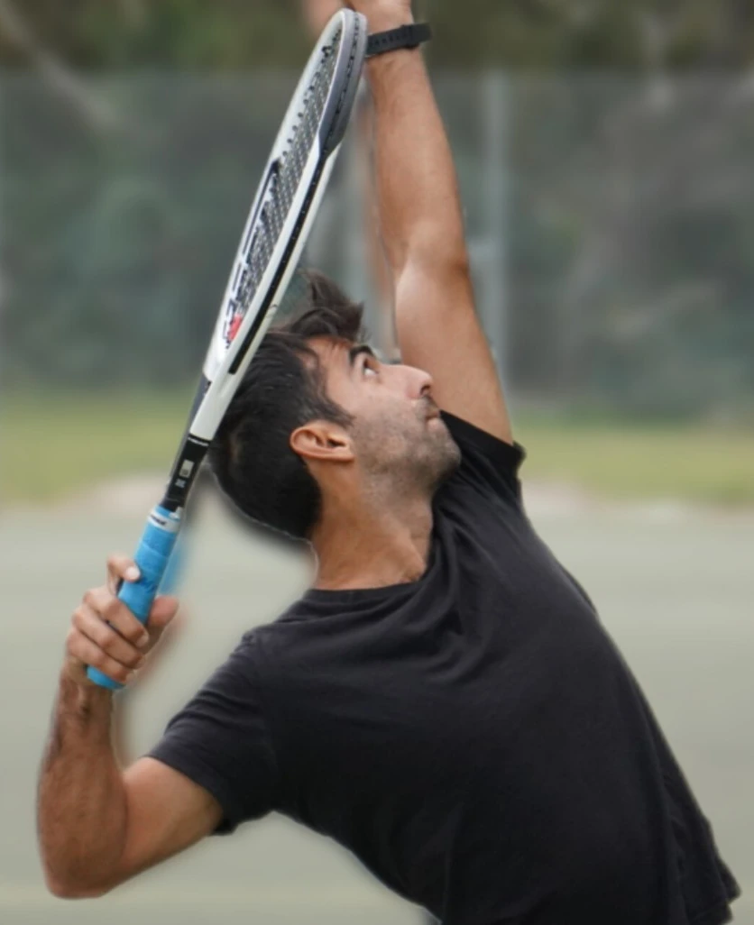 Coach Andy Gomez demonstrating tennis serve mechanics